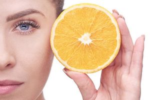 portrait of feminine woman with blue eyes holding orange